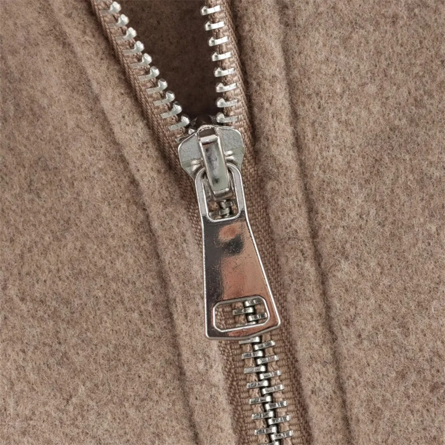 Silver zipper on a tan garment.