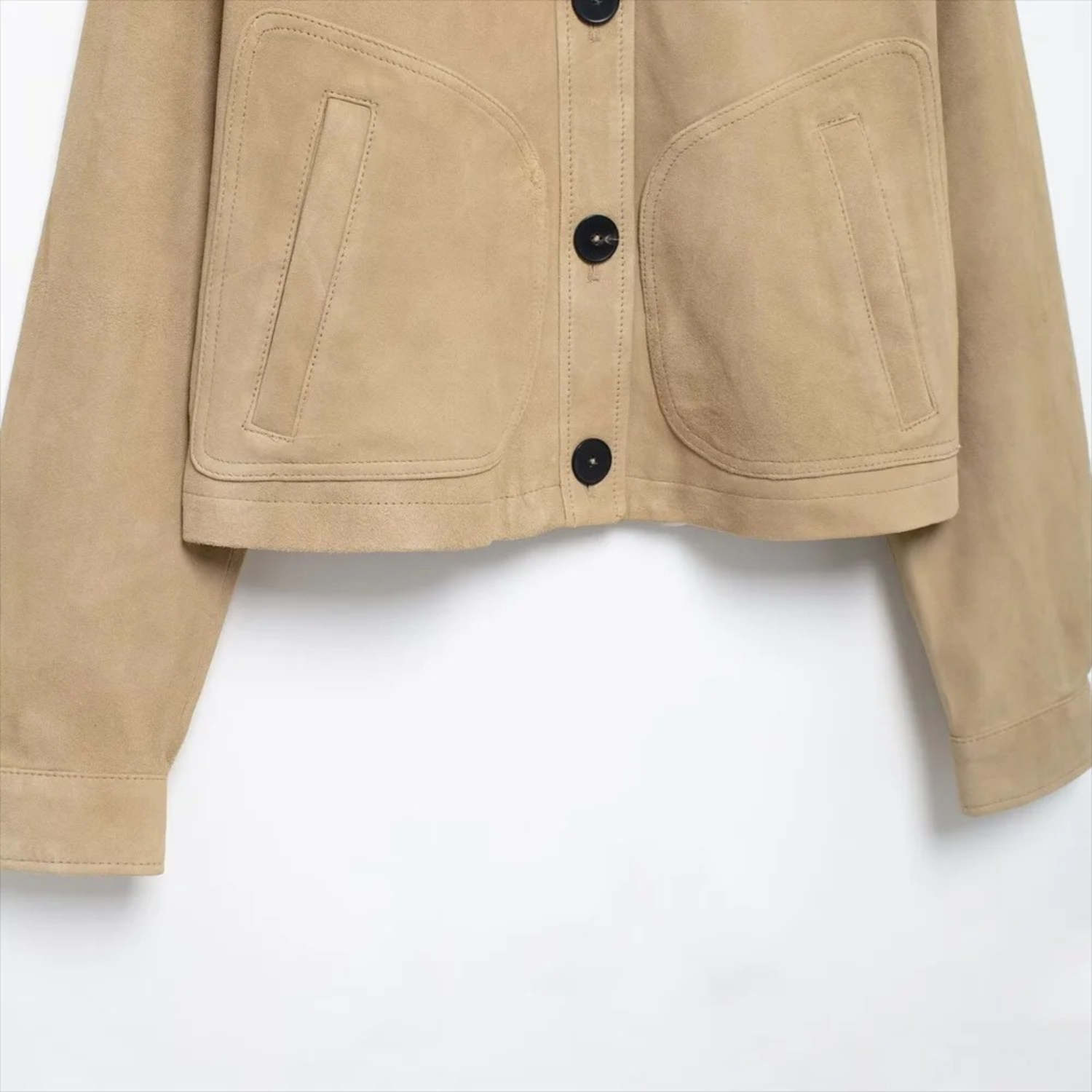 Tan suede jacket with black buttons.
