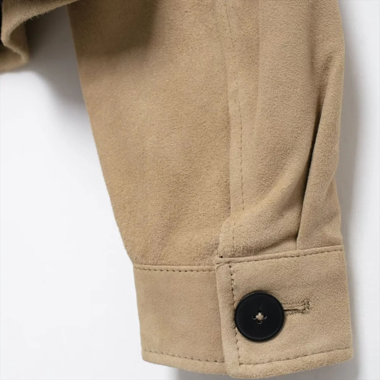 Tan suede jacket sleeve with button.