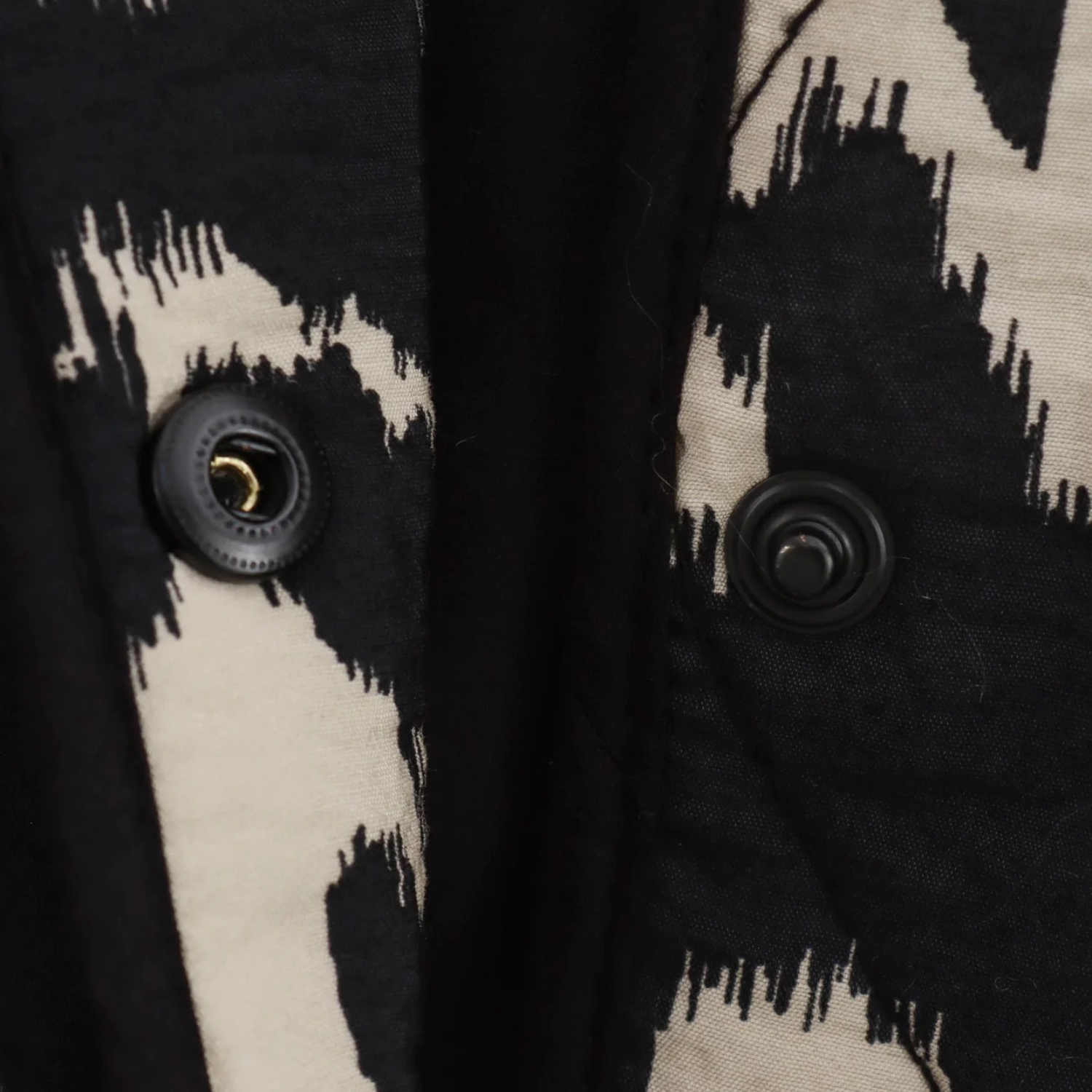 Black and white patterned garment with snap closures.