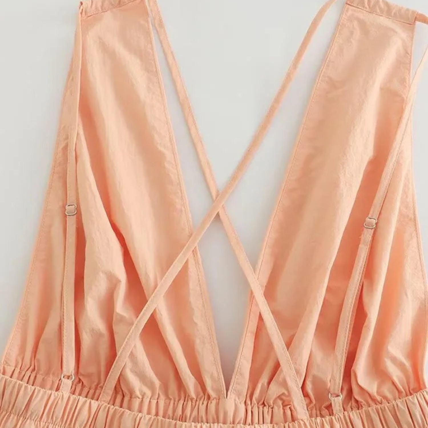 Peach-colored dress with criss-cross straps.